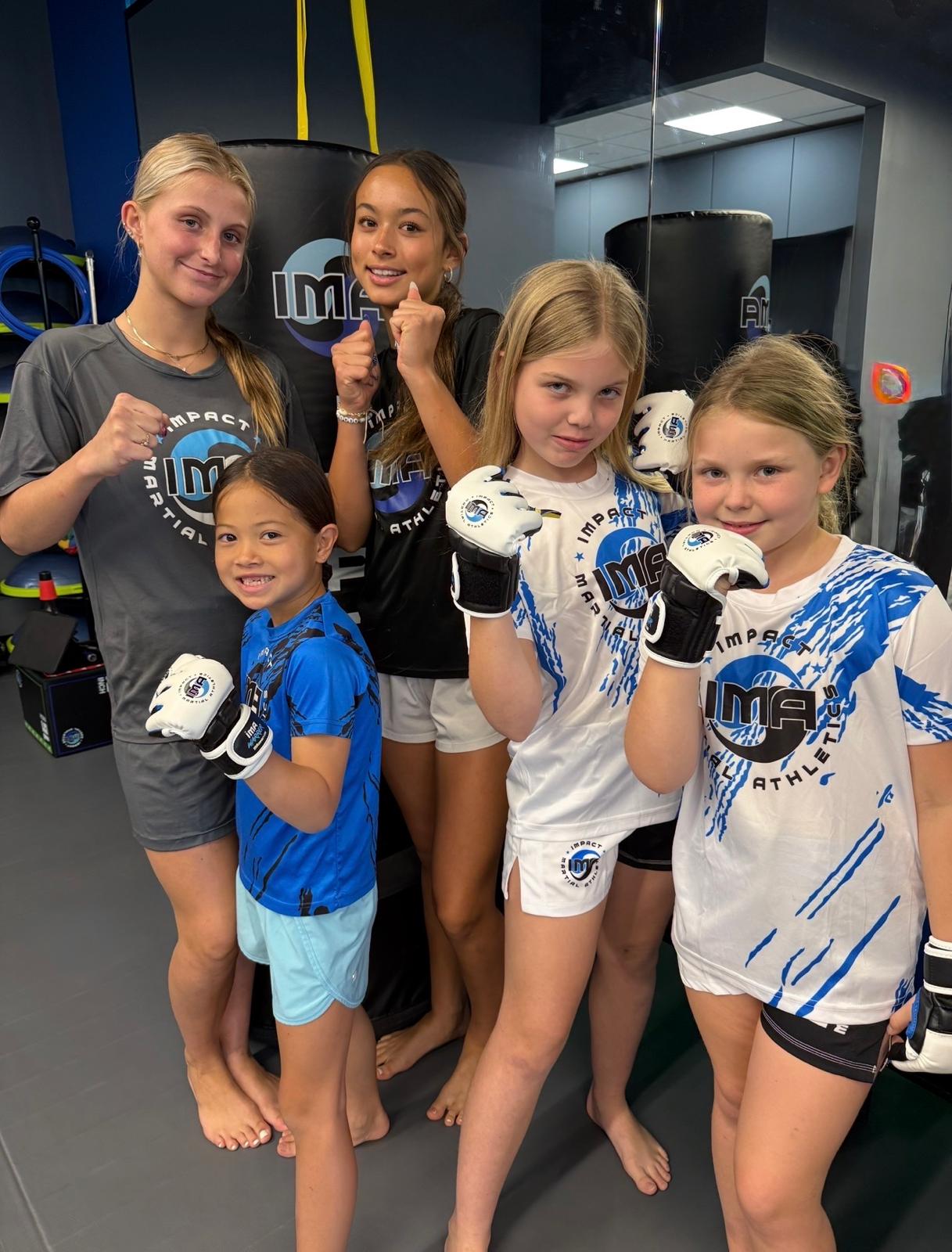 Girls showing fists in group photo at IMA Summer Camp