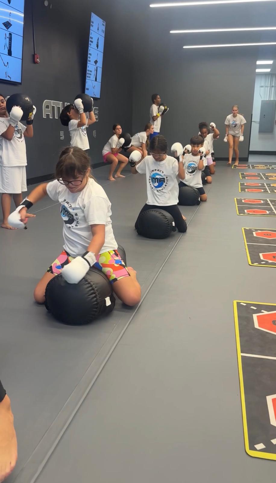 Kids doing ground strength training with heavy bags