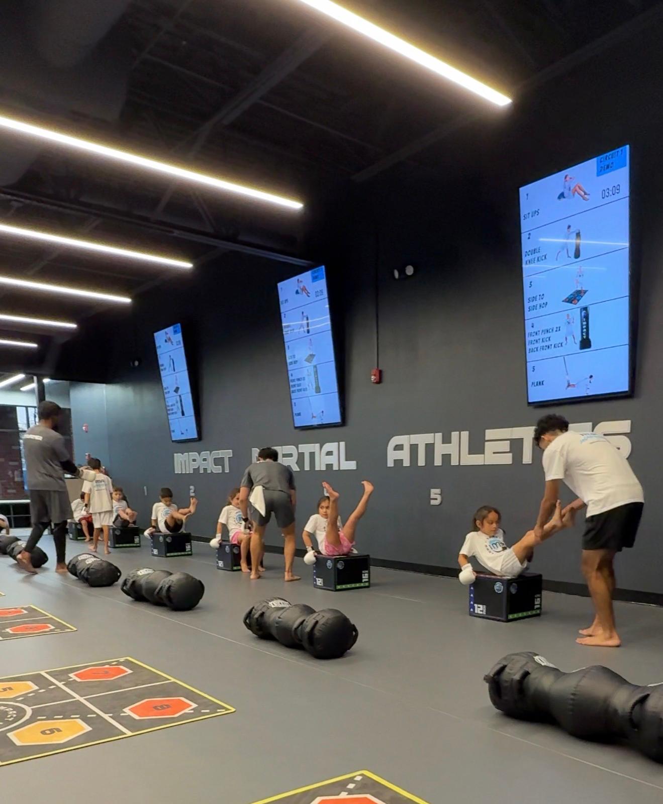 Kids doing sit-ups on heavy bags during circuit training