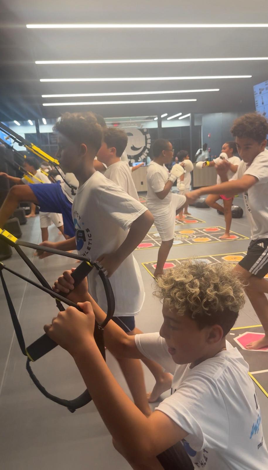 Kids doing TRX suspension training at IMA facility